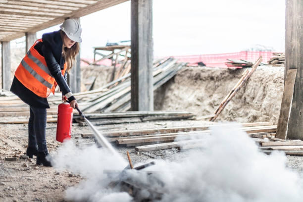 Female rescue worker with a fire extinguisher  on construction site